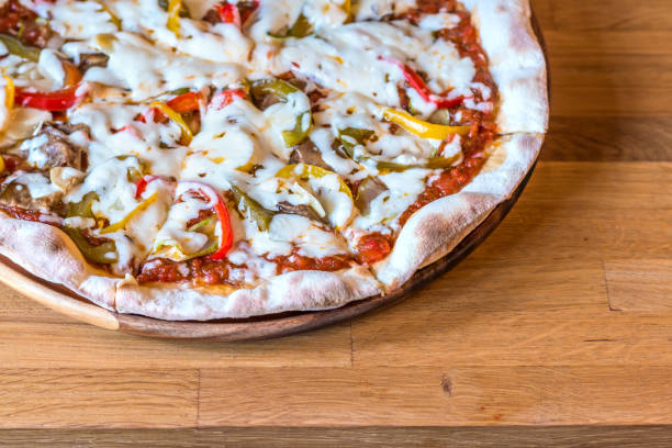 istock Hot pizza with melting cheese on a wooden table 671228698
