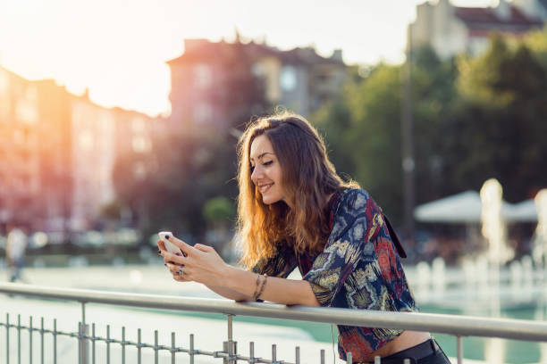 istock Girl leaning on fence and browsing on her smart phone 671246878