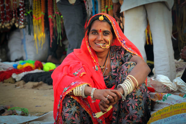 eine unbekannte rajasthani indische frau in bunten kleidung pose für kamera auf pushkar kamel fair gekleidet - camel fair stock-fotos und bilder