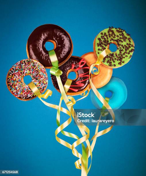 Photo Manipulation Doughnuts Floating Like Balloons In A Blue Background Stock Photo - Download Image Now