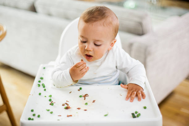 istock Baby boy eating green peas 671259134