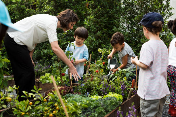 istock Teacher and kids school learning ecology gardening 671259880