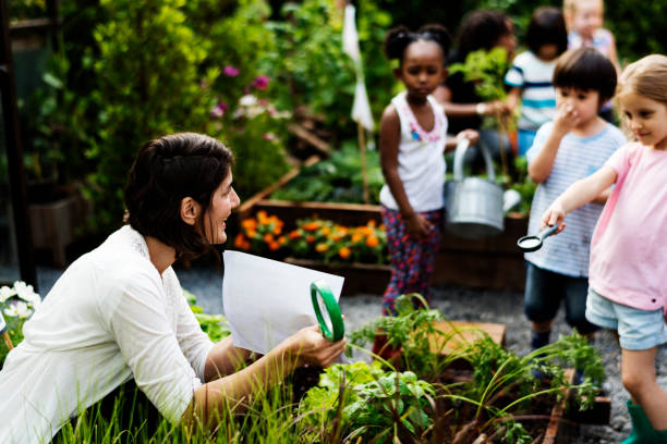 istock Teacher and kids school learning ecology gardening 671259920