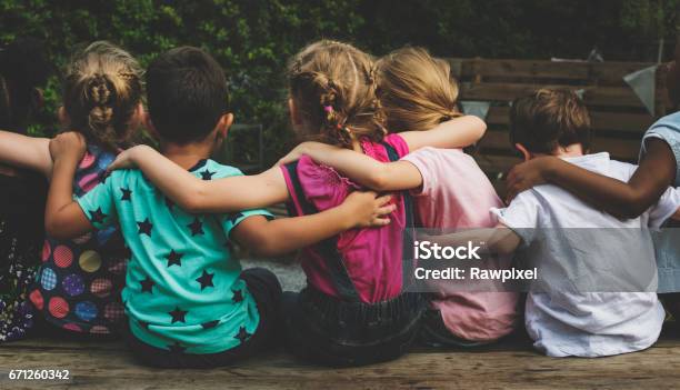 Group Of Kindergarten Kids Friends Arm Around Sitting Together Stock Photo - Download Image Now