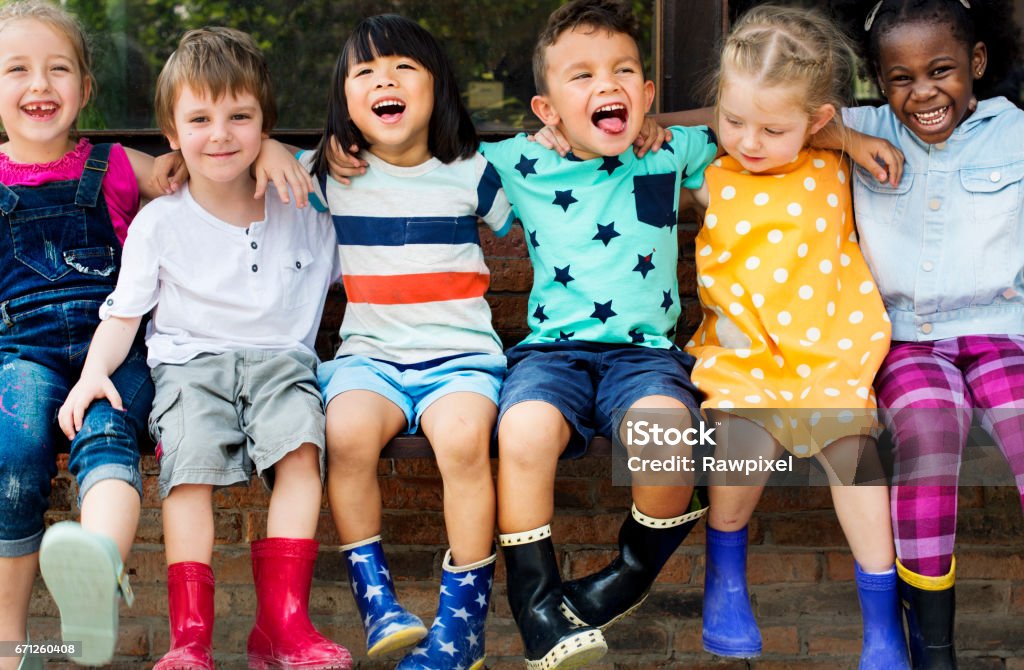 Groep vrienden arm van de kinderen van de kleuterschool rond zitten en glimlachend plezier - Royalty-free Kind Stockfoto