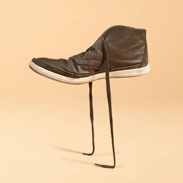 istock Green shoe standing in its laces. Concept photo manipulation. 671263292
