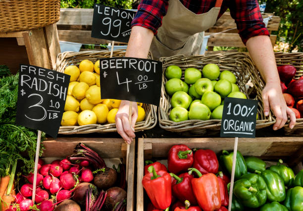 fruttivendolo prepara prodotti agricoli freschi biologici al mercato contadino - organic farmers market market vegetable foto e immagini stock