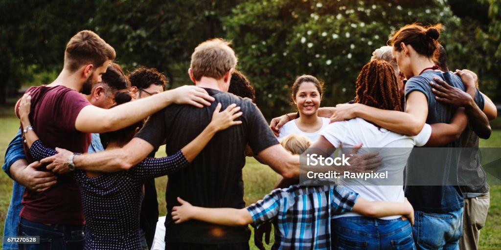Group of people huddle together in the park Community Stock Photo