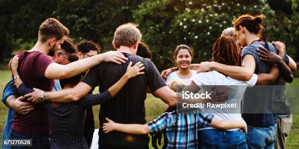 Group Of People Huddle Together In The Park Stock Photo - Download Image Now - Community, Child, Group Of People