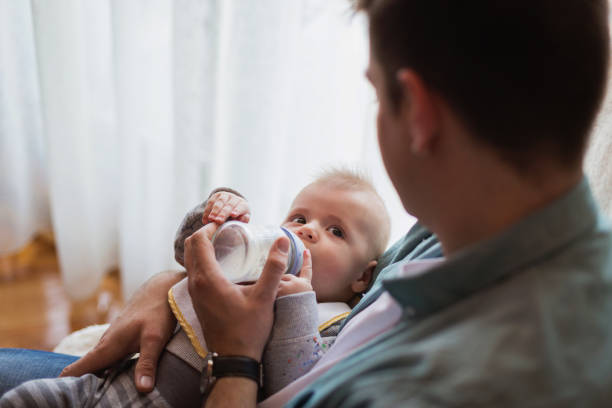 istock Young handsome father feeding his baby boy 671276292