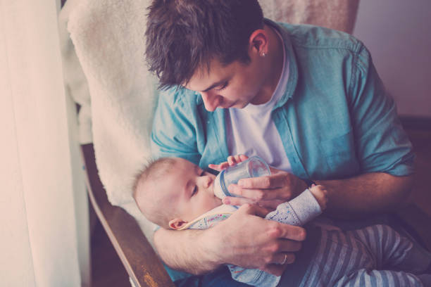 istock Beautiful single father feeding newborn baby 671277348