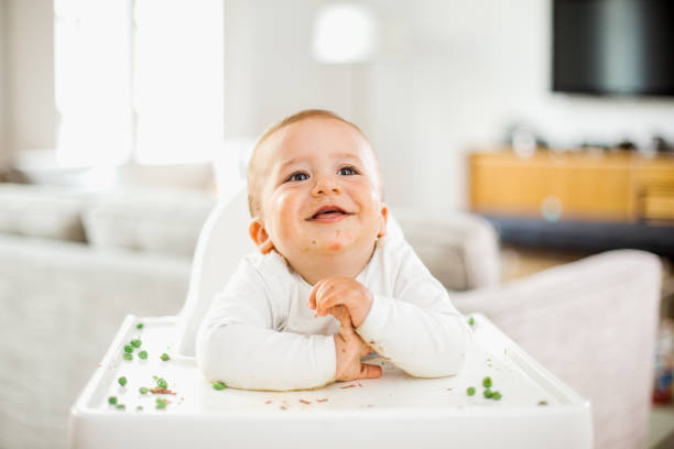 istock Baby boy eating green peas 671281676