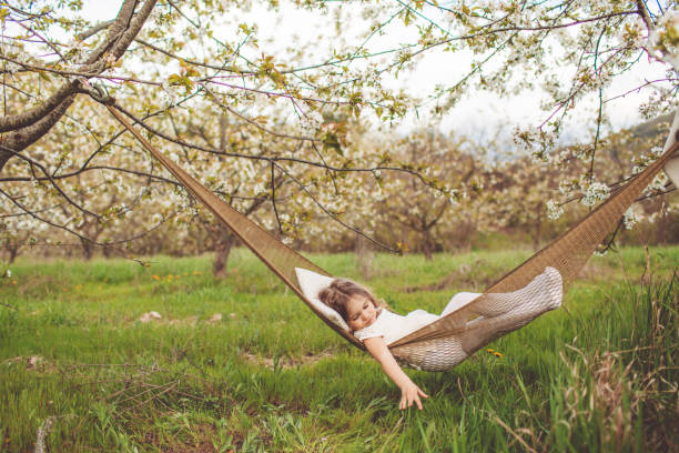 Child girl is resting in hammock outdoors stock photo
