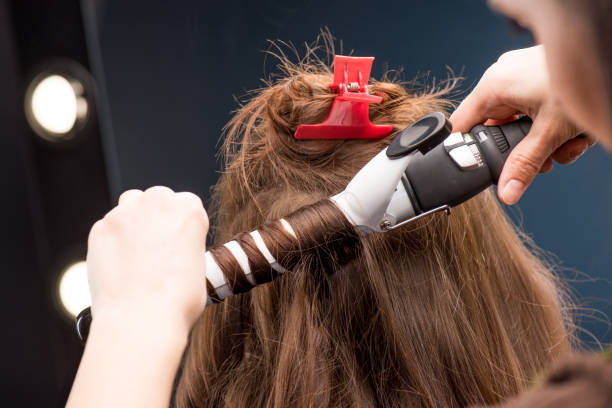 istock Hairstylist curling hair 671299210