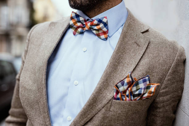 close up of well dressed man's torso. guy wearing jacket, shirt and colorful handkerchief and bow tie - lapel imagens e fotografias de stock