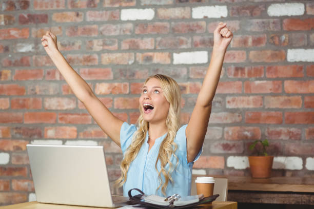 istock Happy businesswoman cheering while sitting in office 671307200