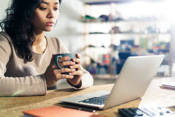 istock Businesswoman with coffee looking at the screen 671307712