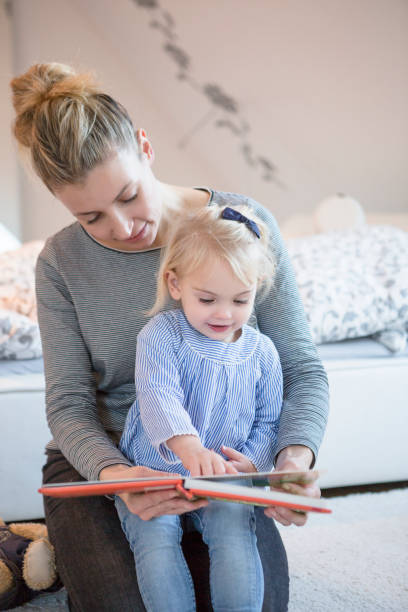 istock A young German mother cuddling whilst reading a book 671316630