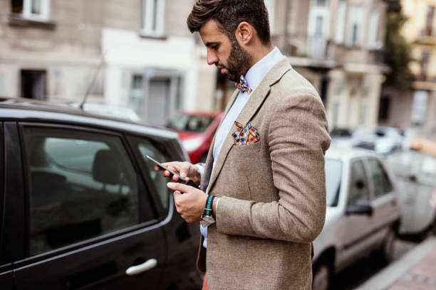 istock Young stylish businessman checking his phone on the sidewalk 671317456