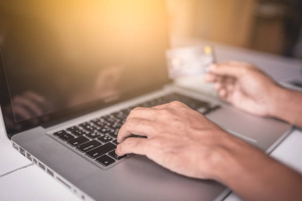 istock Male hand hands holding a credit card and using laptop computer. 671327262