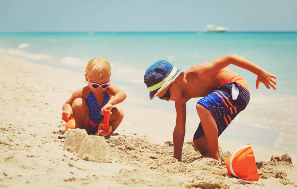 istock kids play with sand on summer beach 671327498