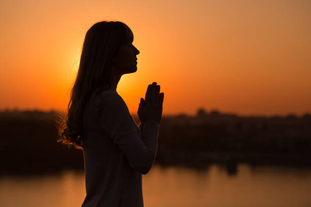 mujer meditando al aire libre - worship place fotografías e imágenes de stock