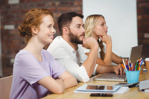 istock Focused business people with technologies sitting in office 671334612
