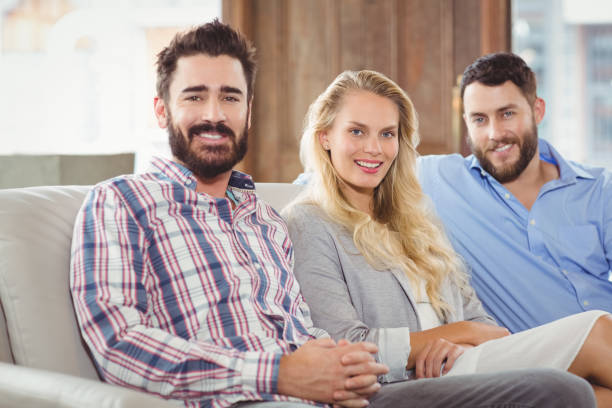 istock Portrait of happy colleagues sitting on sofa 671337664