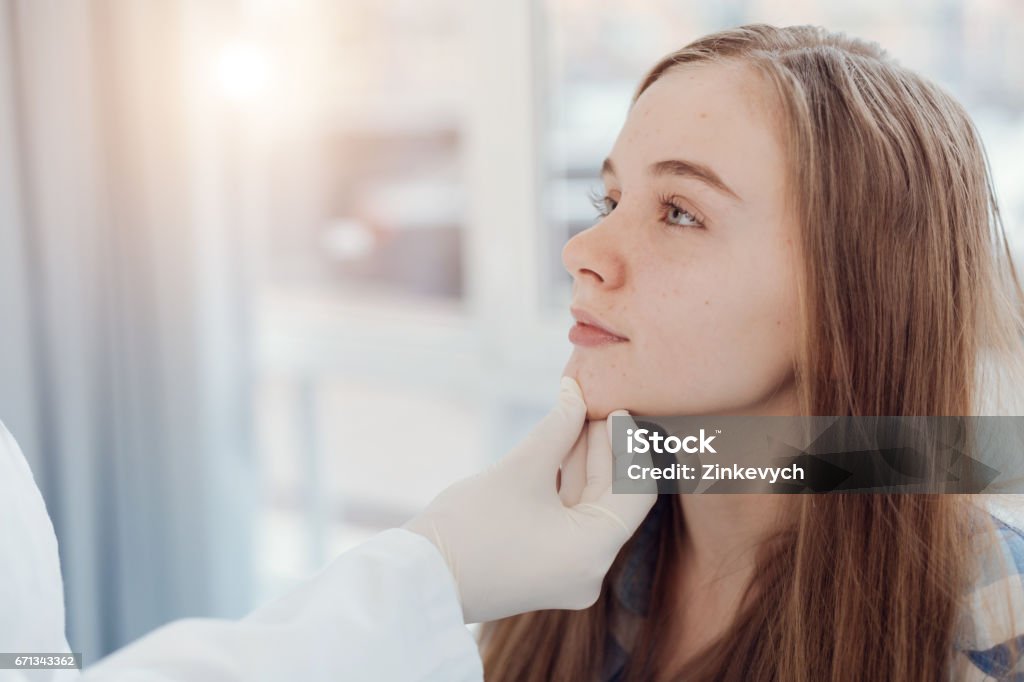 Experimentou o pediatra examinando o rosto de paciente no hospital - Foto de stock de Dermatologia royalty-free