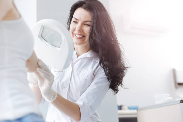 istock Delighted young dermatologist using medical loupe in the clinic 671357072