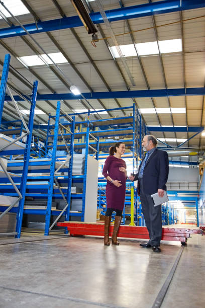 istock Senior manager in discussion with coworkers in a warehouse 671360290