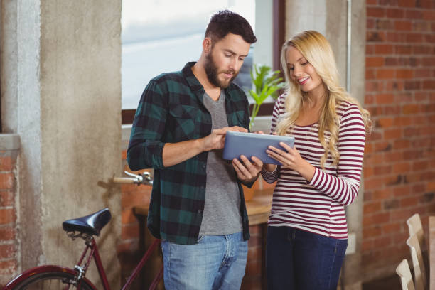 istock Cheerful businesswoman with colleague using digital tablet 671360392