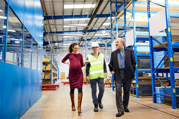 istock Business team walking in warehouse and discussing 671360496