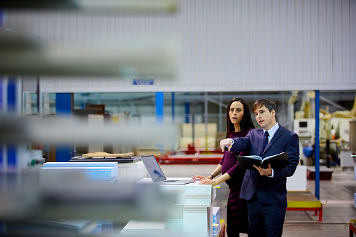 Businessman with female supervisor working on factory production line