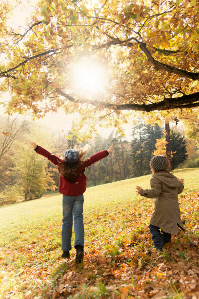 istock Girls playing in the autumn park 671362532