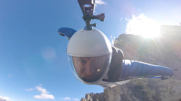 vue rapprochée de wingsuit flier dans la descente au-dessus du mont - wingsuit photos et images de collection