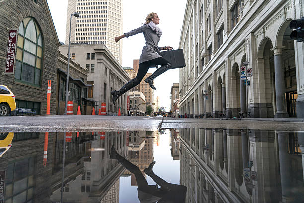 Business woman crosses city street after rain  puddle photos stock pictures, royalty-free photos & images