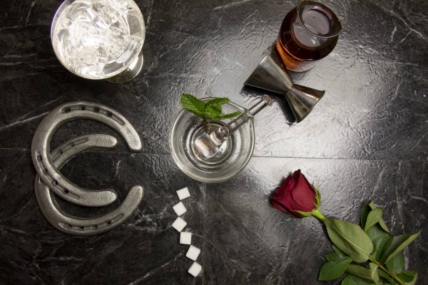 Lay flat deconstructed mint julep Lay flat overhead of bar countertop with deconstructed elements of Kentucky Derby mint julep with horse shores and red rose. kentucky derby stock pictures, royalty-free photos & images
