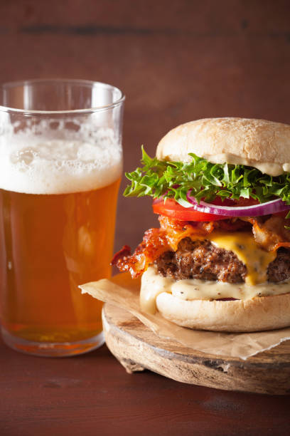 istock bacon cheese burger with beef patty, tomato and onion beer 671375706
