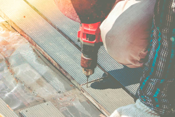 istock Carpenter hand or hand of worker drills a hole with wooden plank using electric drill machine. 671383148