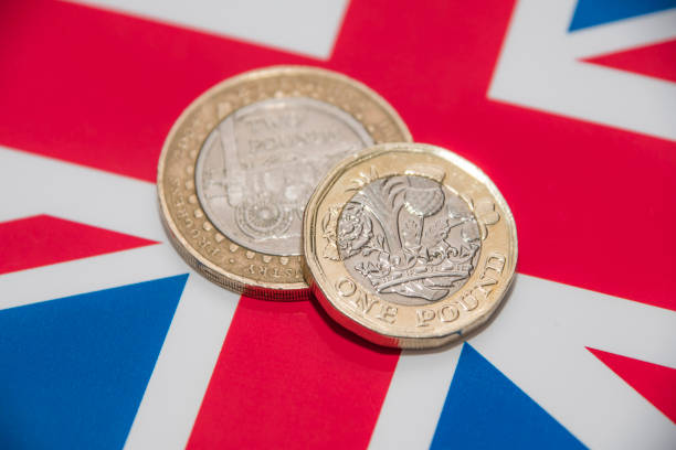 istock One and Two Pound coins on UK flag 671385646