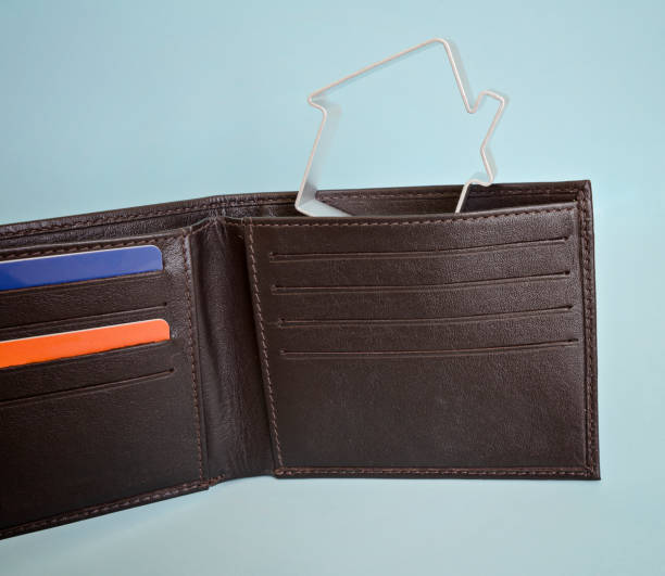 istock Leather wallet with credit cards and a small house 671385706
