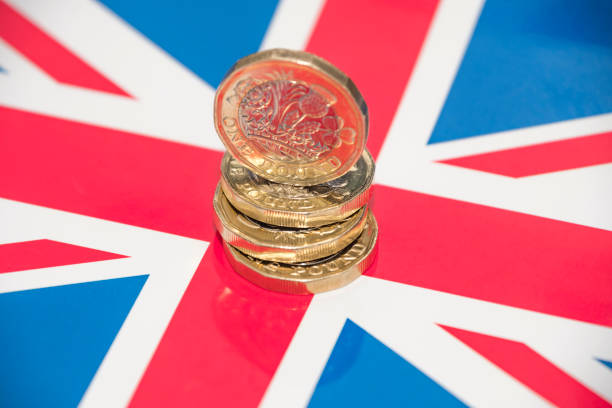 istock Stack of UK 1 Pound Coins and Union Jack Flag 671385868