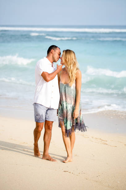 istock Beautiful Couple Walking and Kissing on Beach 671386174