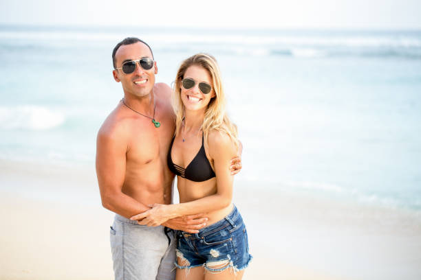 istock Happy Couple Embracing on Summer Beach 671386208