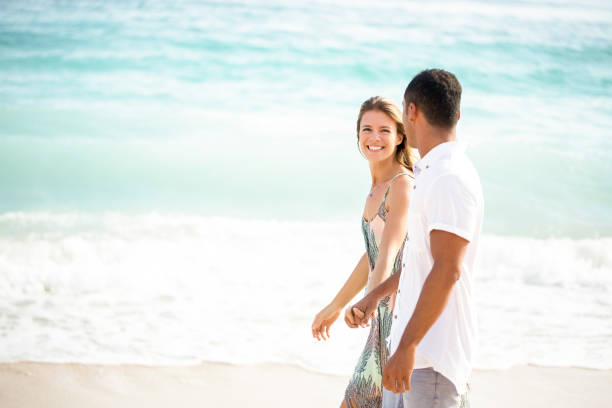 istock Happy Couple Walking on Summer Beach Together 671386222