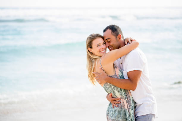 istock Loving Couple Embracing on Summer Beach 671386240