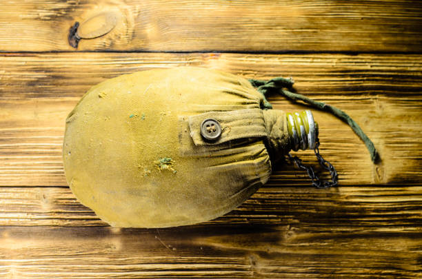 army flask in rag cover on wooden table - water bottle survival military bottle imagens e fotografias de stock