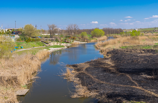 Sura river with burnt riverside at early spring season near Dnepr city, Ukraine