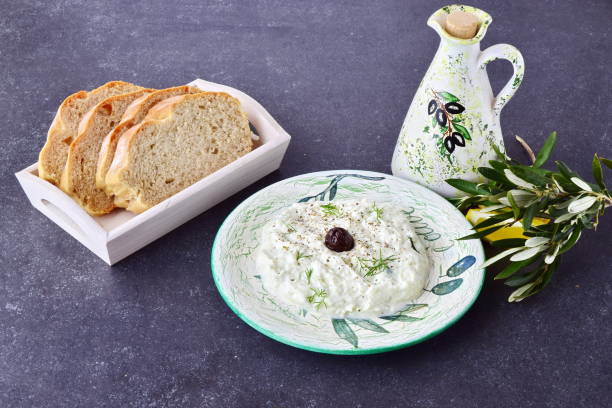 tzatziki grego tradicional molho com azeitonas, frasco de óleo de oliva, limão e pão sobre um fundo cinzento e abstrato. conceito de alimentação saudável - vinegar bottle herb white - fotografias e filmes do acervo